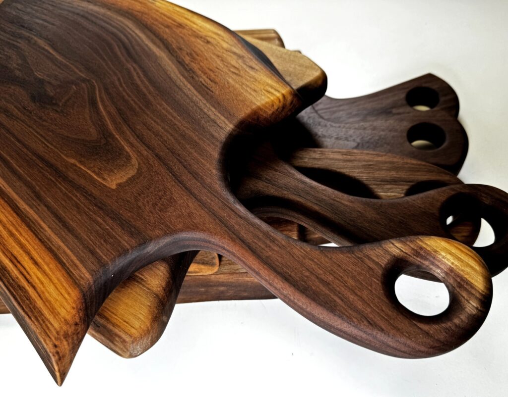 a stack of handmade walunt charcuterie boards